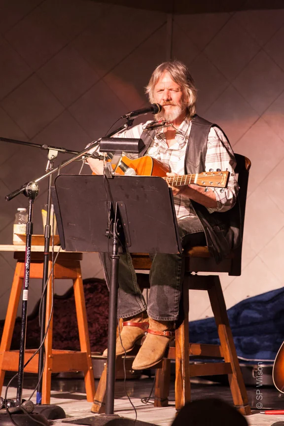 Michael Seward singing and playing acoustic guitar during a live performance